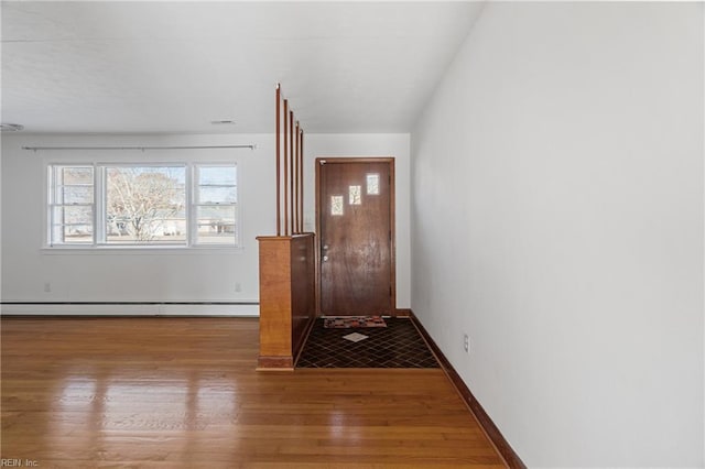 doorway to outside with baseboard heating and wood-type flooring