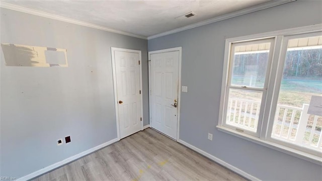 spare room with crown molding and light hardwood / wood-style flooring