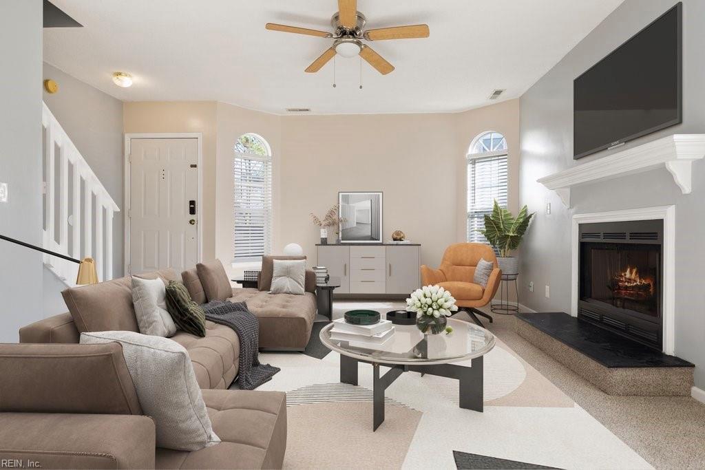 carpeted living room with ceiling fan and a healthy amount of sunlight