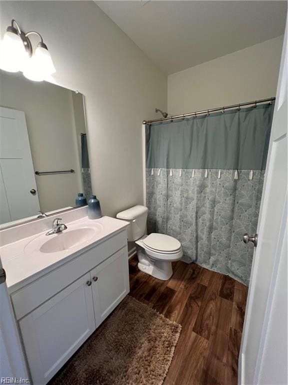 bathroom with wood-type flooring, vanity, and toilet