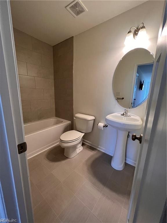 bathroom featuring tiled shower / bath and toilet