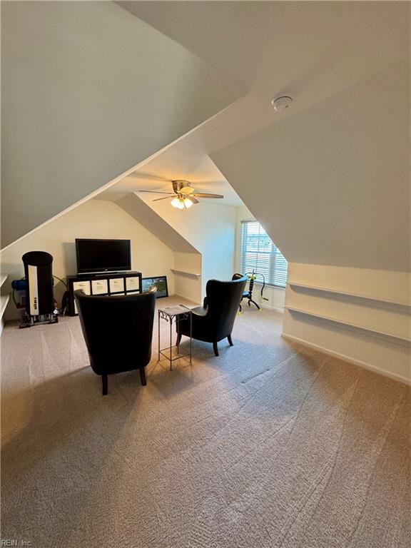 carpeted bedroom with lofted ceiling