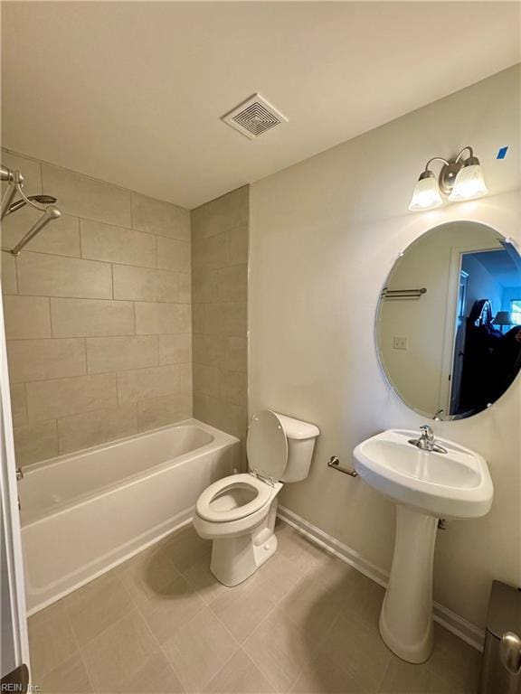 full bathroom with tile patterned floors, tiled shower / bath combo, toilet, and sink