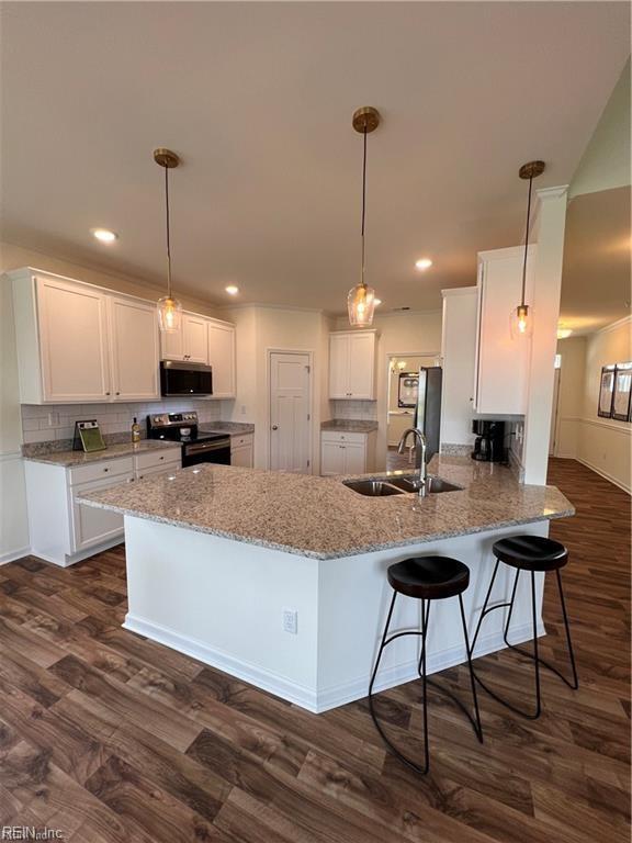 kitchen featuring kitchen peninsula, appliances with stainless steel finishes, dark hardwood / wood-style flooring, and white cabinetry