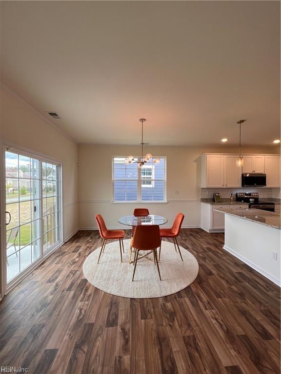 dining room with dark hardwood / wood-style flooring and a notable chandelier