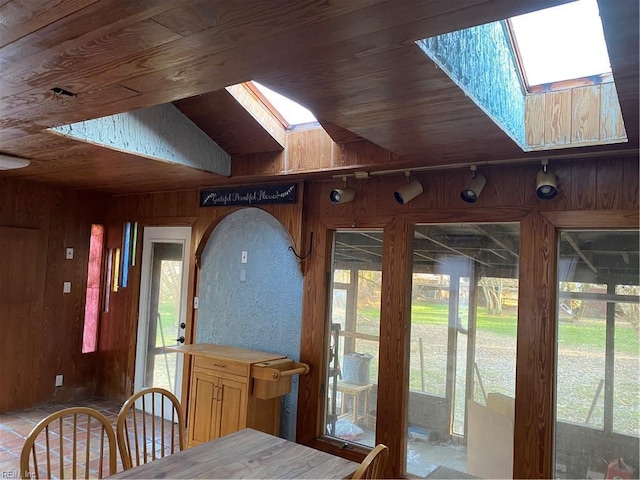 interior space with a skylight, a healthy amount of sunlight, and wood ceiling