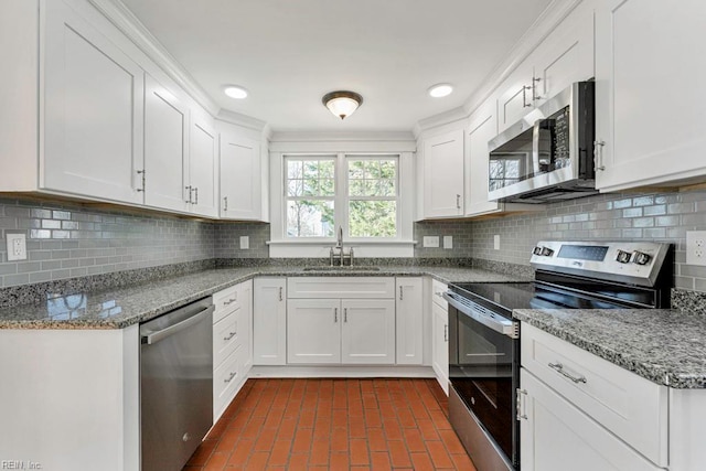 kitchen with tasteful backsplash, white cabinetry, sink, and appliances with stainless steel finishes