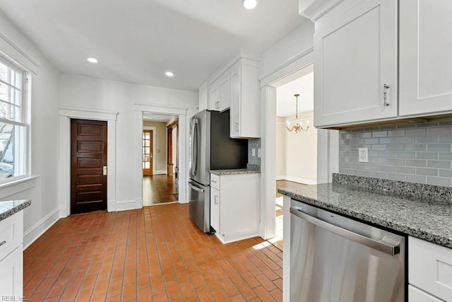 kitchen featuring tasteful backsplash, light stone counters, white cabinets, and stainless steel appliances