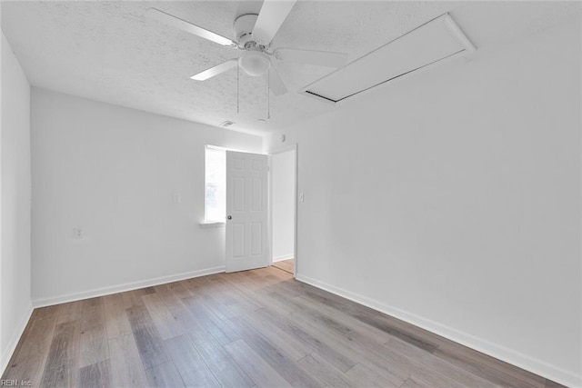 empty room with ceiling fan, a textured ceiling, and light hardwood / wood-style flooring