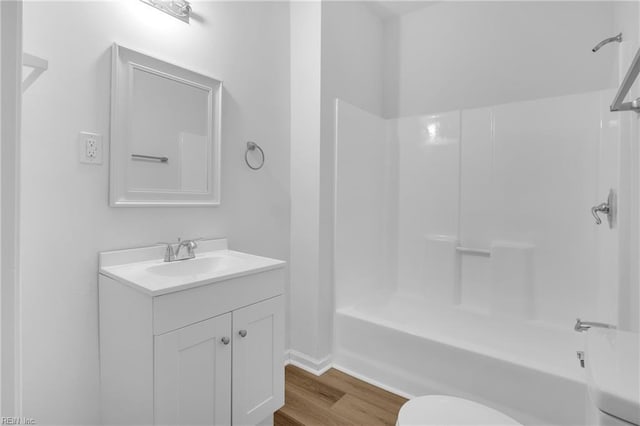 full bathroom with hardwood / wood-style floors, vanity, toilet, and shower / washtub combination