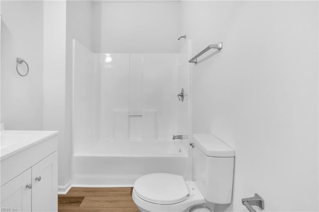 full bathroom with hardwood / wood-style floors, vanity, bathing tub / shower combination, and toilet