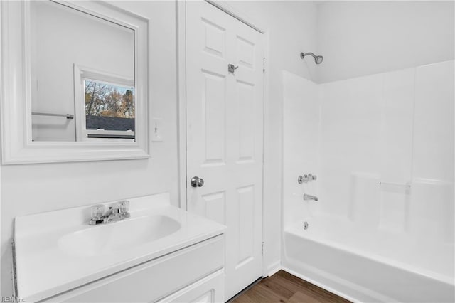 bathroom featuring hardwood / wood-style flooring, vanity, and shower / bath combination