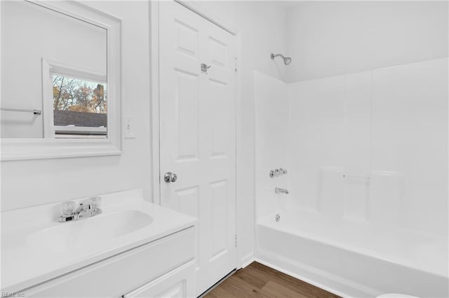 bathroom with hardwood / wood-style floors, vanity, and tub / shower combination