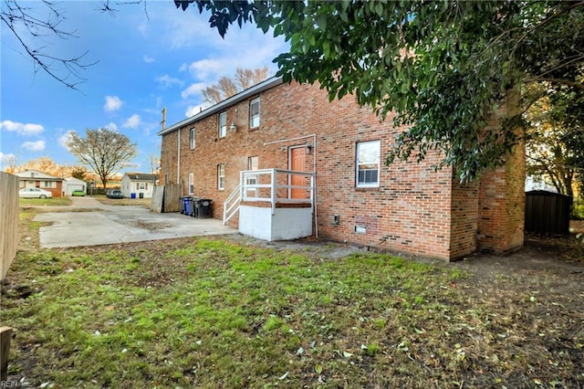 rear view of property featuring a lawn and a patio