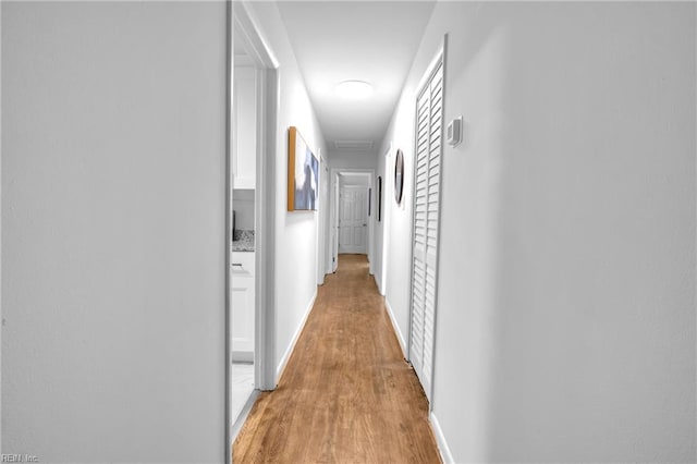 hallway with light hardwood / wood-style flooring