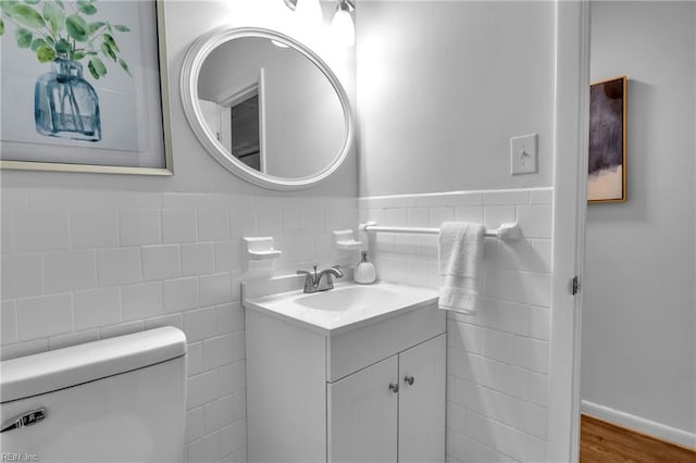 bathroom featuring vanity, hardwood / wood-style flooring, toilet, and tile walls