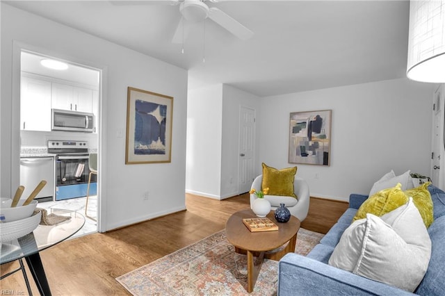 living room with ceiling fan and light wood-type flooring