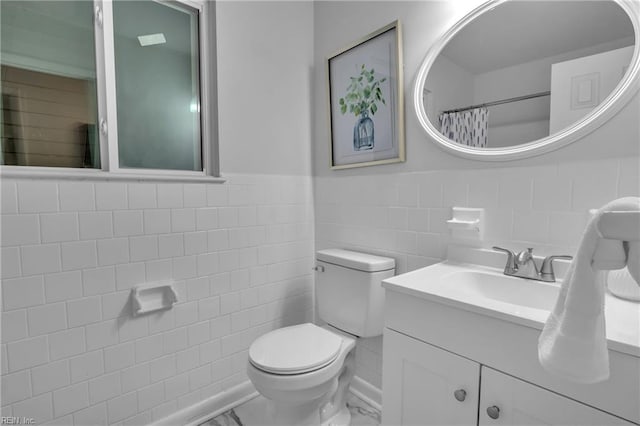 bathroom with vanity, curtained shower, toilet, and tile walls