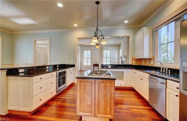 kitchen with kitchen peninsula, a wealth of natural light, a center island, and appliances with stainless steel finishes