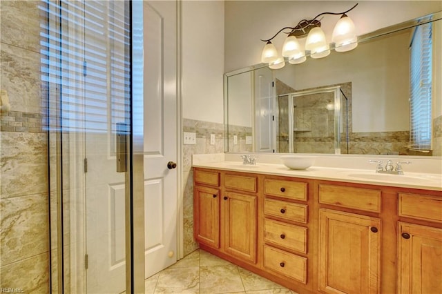 bathroom with vanity, plenty of natural light, tile walls, and a shower with shower door