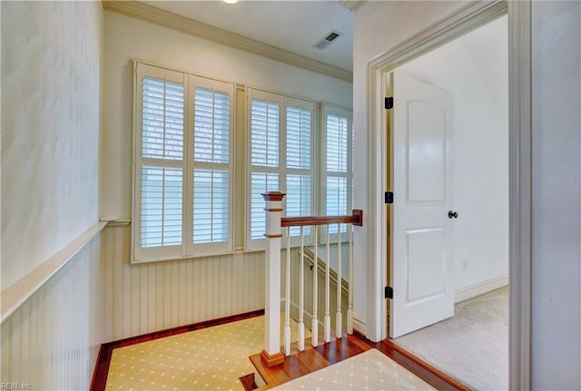 corridor featuring ornamental molding and carpet floors