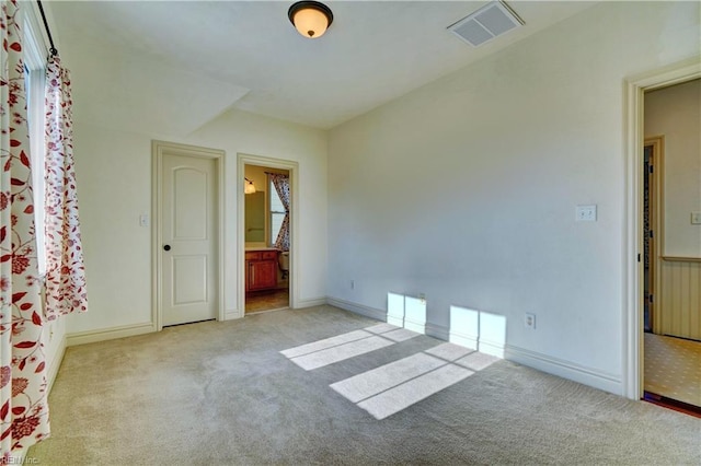 interior space featuring light colored carpet and ensuite bath