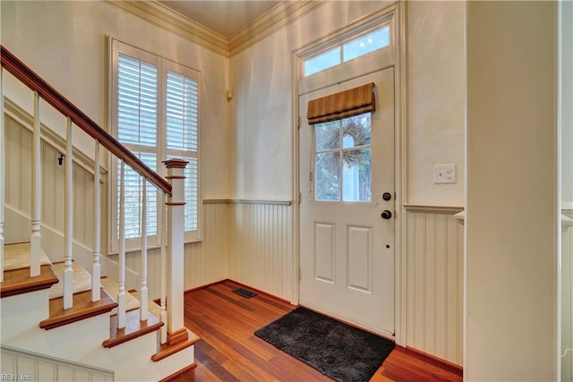 entryway with wood-type flooring and ornamental molding