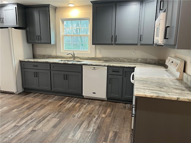 kitchen featuring gray cabinetry, dark hardwood / wood-style flooring, white appliances, and sink