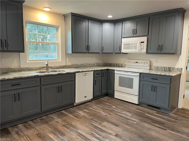 kitchen featuring dark hardwood / wood-style flooring, white appliances, gray cabinets, and sink