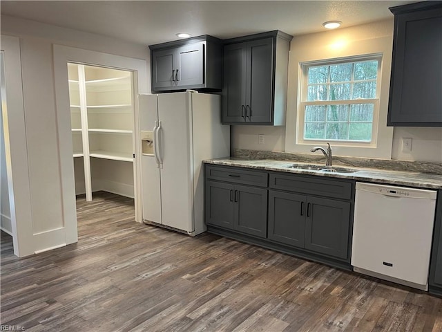 kitchen featuring white appliances, dark hardwood / wood-style floors, gray cabinetry, and sink