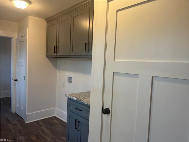 clothes washing area with hookup for a washing machine, dark wood-type flooring, and cabinets