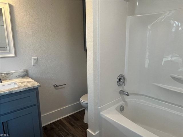 full bathroom featuring washtub / shower combination, vanity, wood-type flooring, and toilet