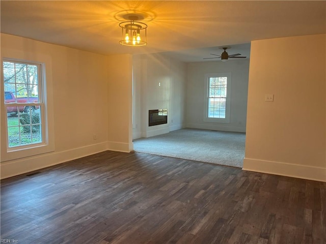 unfurnished living room with dark hardwood / wood-style floors and ceiling fan