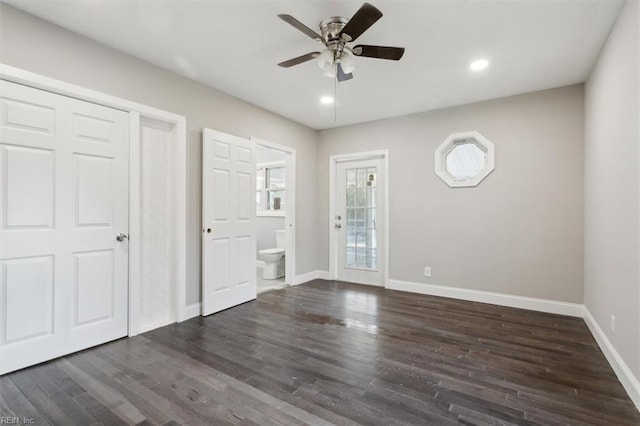 interior space with ceiling fan, dark hardwood / wood-style floors, and ensuite bathroom