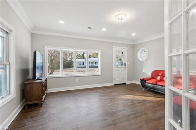 foyer entrance featuring dark hardwood / wood-style flooring, ornamental molding, and a healthy amount of sunlight