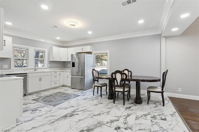 kitchen with white cabinetry, a healthy amount of sunlight, and high end refrigerator