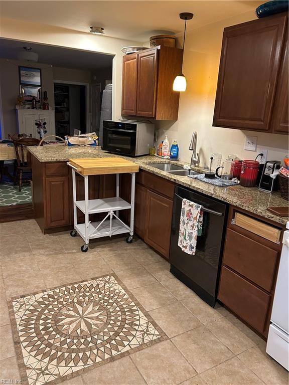 kitchen with kitchen peninsula, sink, pendant lighting, light tile patterned floors, and black dishwasher