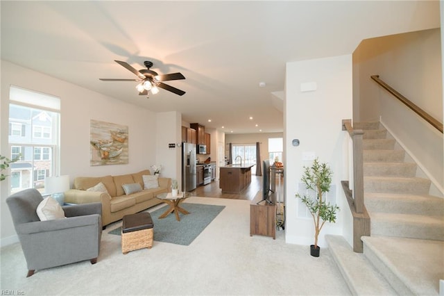 living room with ceiling fan, light hardwood / wood-style floors, and sink