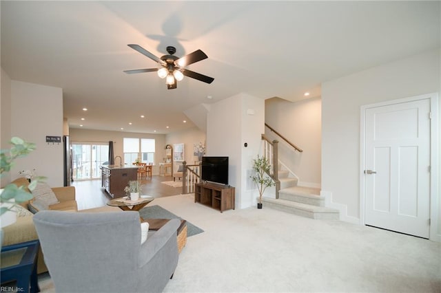 carpeted living room with ceiling fan