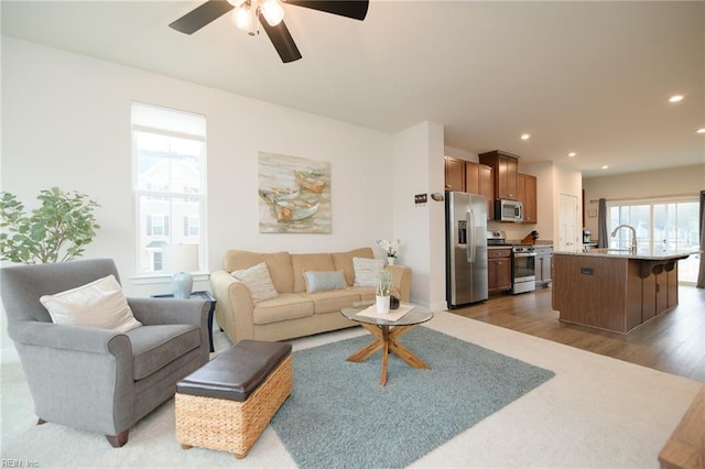 living room with ceiling fan, dark hardwood / wood-style floors, plenty of natural light, and sink