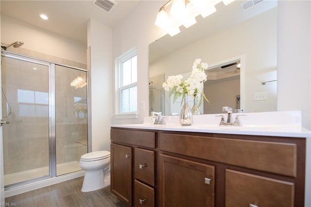 bathroom with vanity, toilet, an enclosed shower, and wood-type flooring