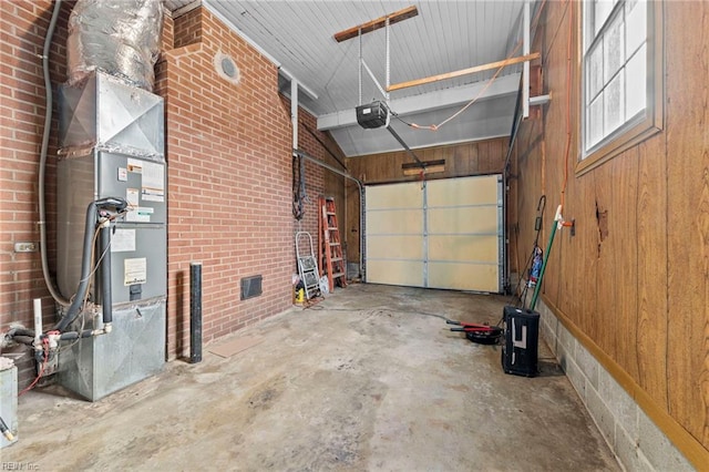 garage featuring a garage door opener and wooden walls