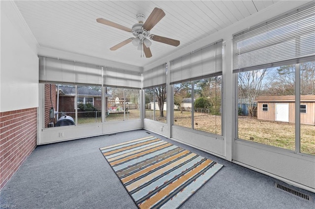 unfurnished sunroom with ceiling fan