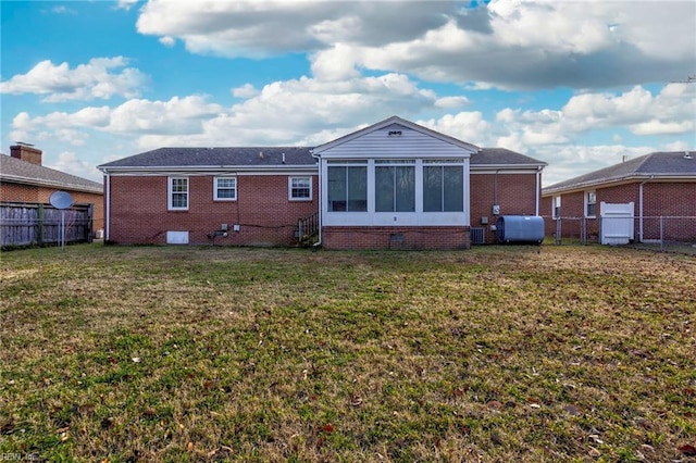 back of property featuring a sunroom and a lawn