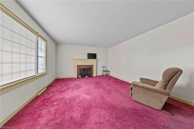 sitting room with baseboard heating, carpet, and a brick fireplace