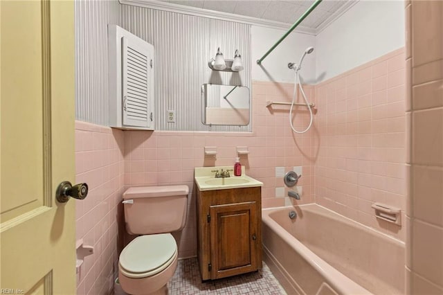 full bathroom with ornamental molding, toilet, vanity, tile walls, and tiled shower / bath