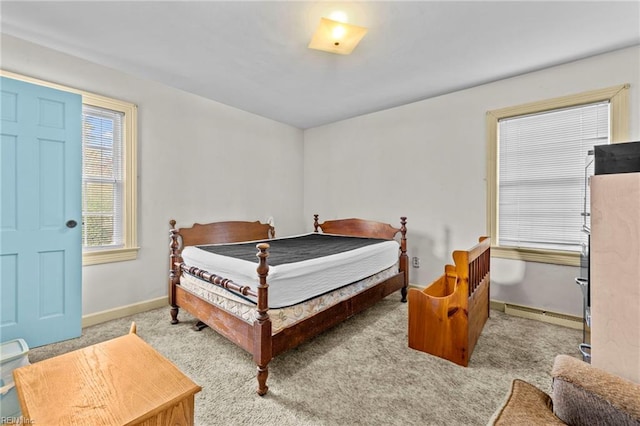 bedroom with light colored carpet and a baseboard radiator