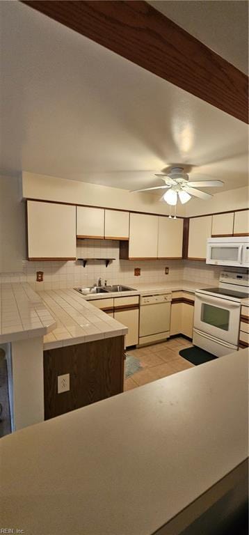 kitchen featuring decorative backsplash, white appliances, ceiling fan, white cabinets, and tile counters