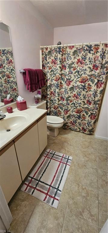 bathroom featuring tile patterned flooring, vanity, and toilet