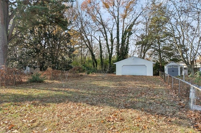 view of yard with a garage and an outbuilding